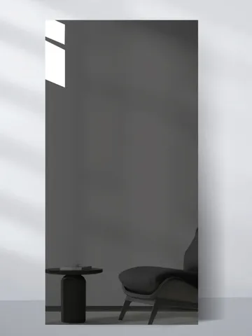 Gray Mirror panel: a smoked gray, mirror-look sheet leaning on a pale wall, reflecting a chair and side table