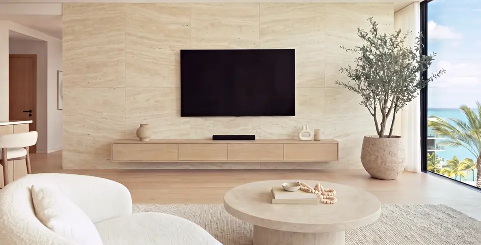 Living room with a floor-to-ceiling travertine-look wall behind the TV and a floating oak console